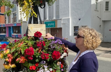 A Barnstaple in Bloom memorial baskets plant stand being watered by a volunteer. Credit: Barnstaple in Bloom