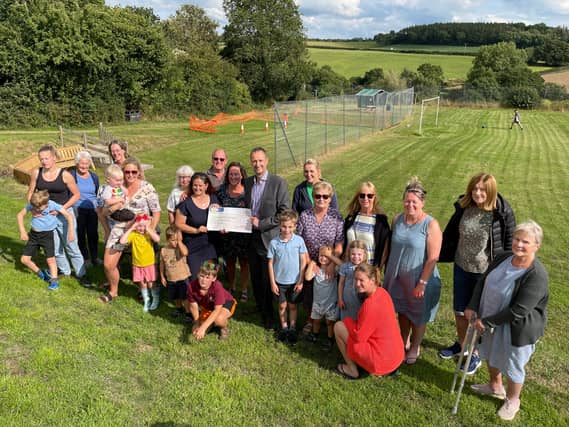 Local parents, children and supporters are hoping one last burst of support will help the village play area come back to life. They are pictured on site receiving a cheque on behalf of the Philip J Mi