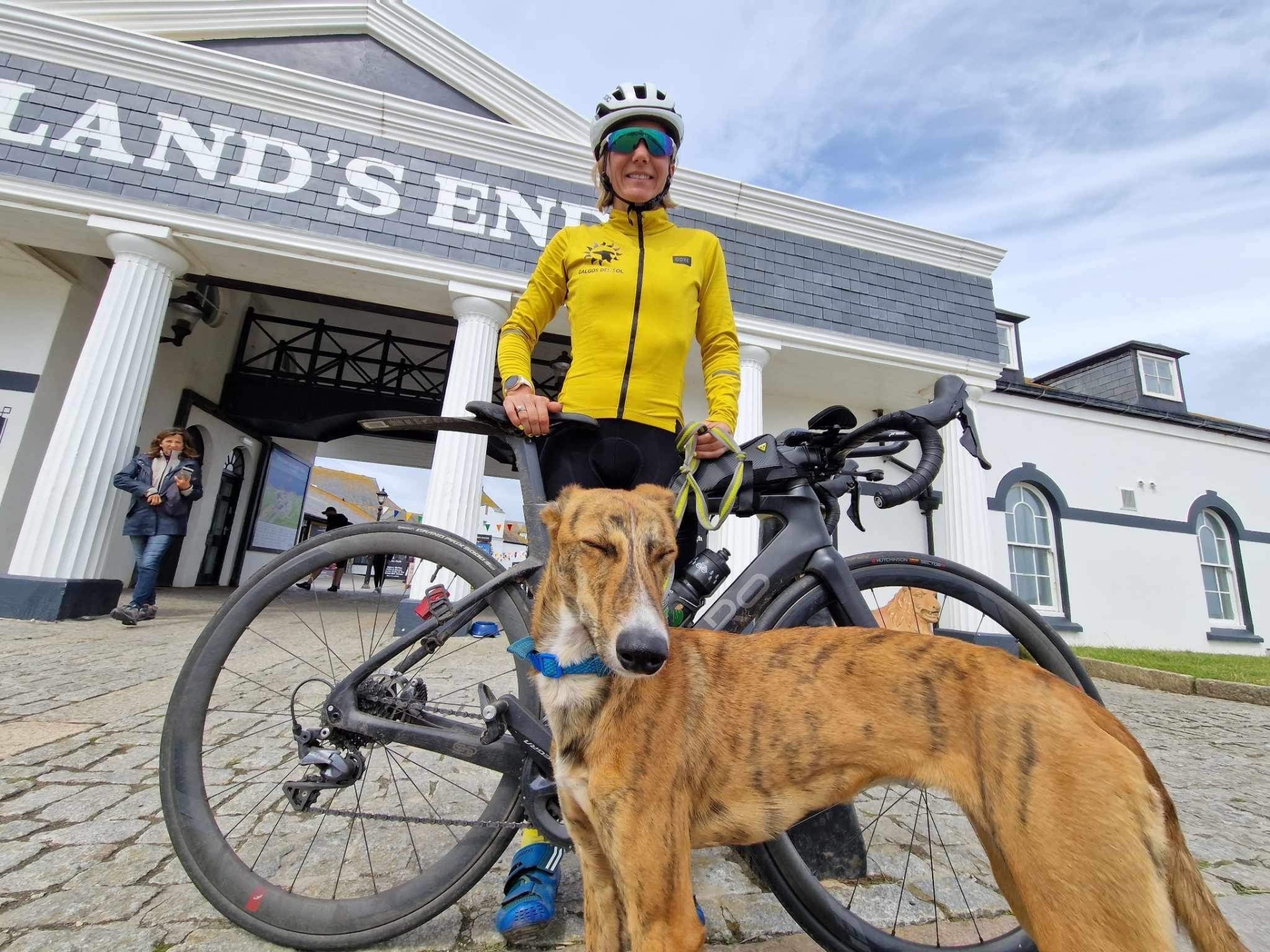 Louise Harris and her dog Peanut at Land's End, who is also a Spanish Galgos and the breed she was fundraising for during her record breaking cycle. Credit: Glyn Brackenbury