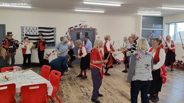Both Torrington and Roscoff twinners have a go at stick dancing.