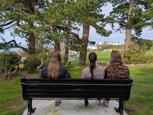 Mike Edmund’s granddaughters Lucy, Natasha and Caitlin on his memorial bench.