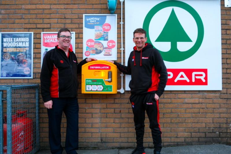 Tim and Nick Blight proudly showing the new Defib on the shop wall