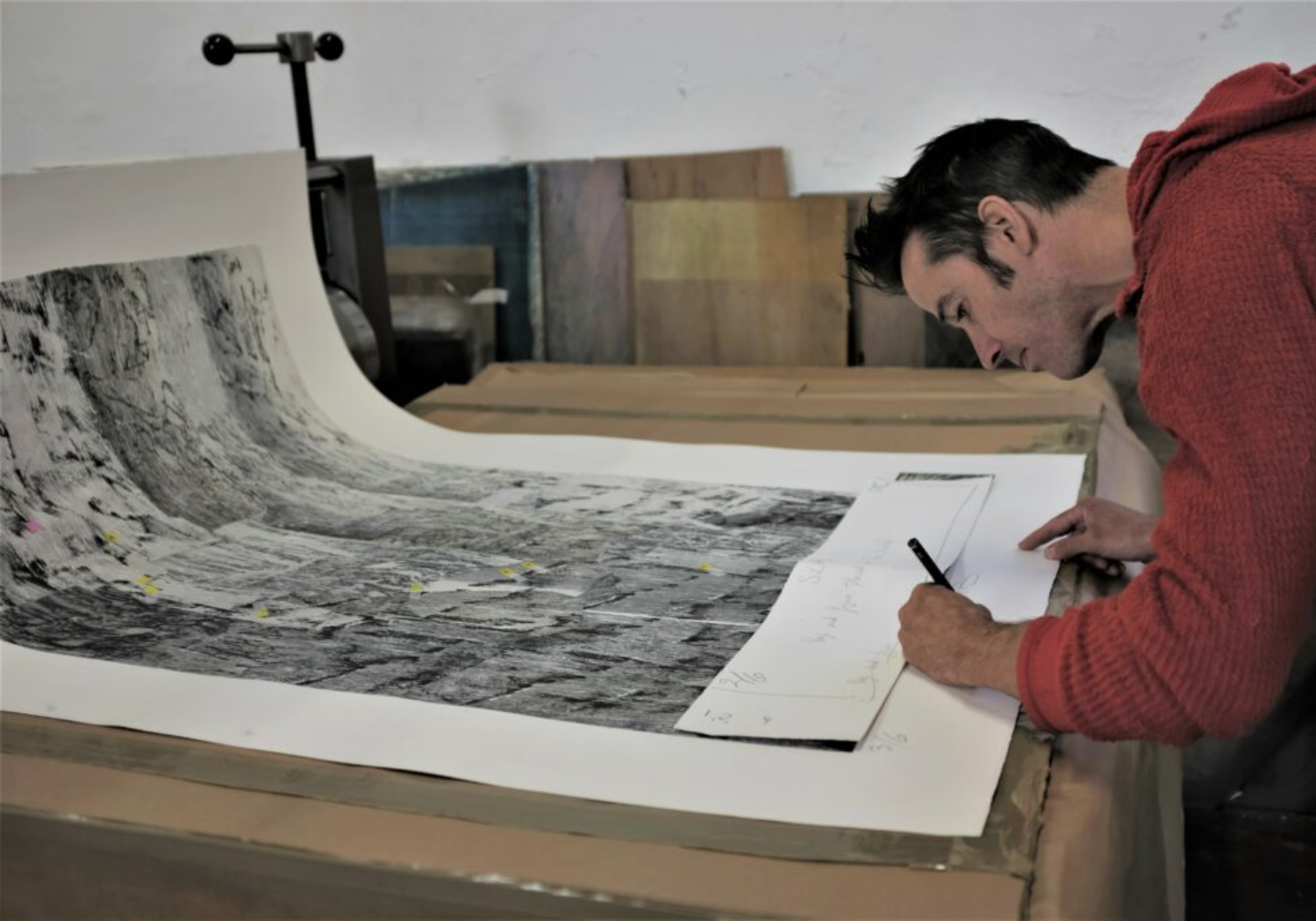 Tom Randall signing the prints being exhibited at Battersea