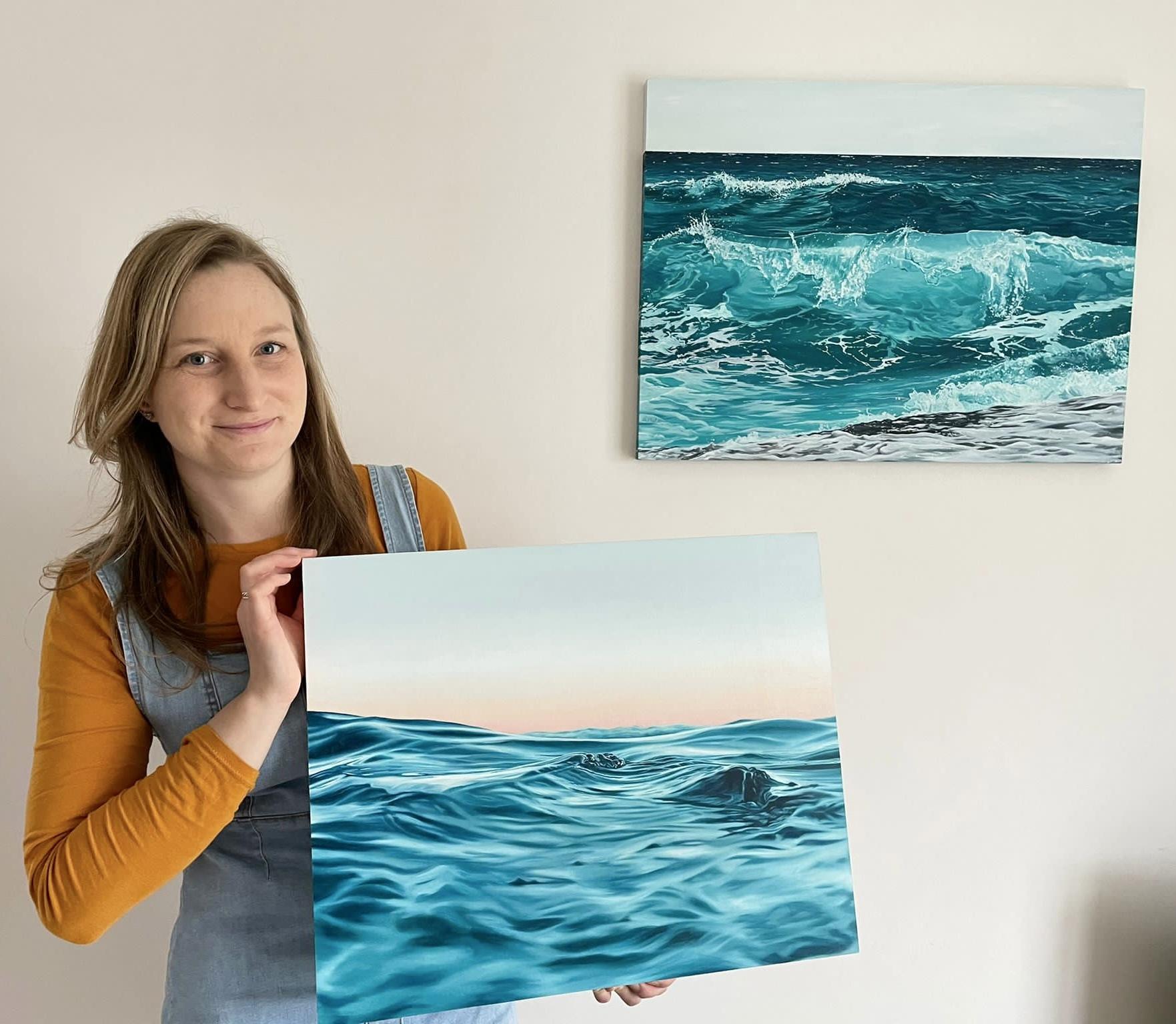 Clare Willcocks holding oil painting Serenity with Azure behind - Credit: Submitted
